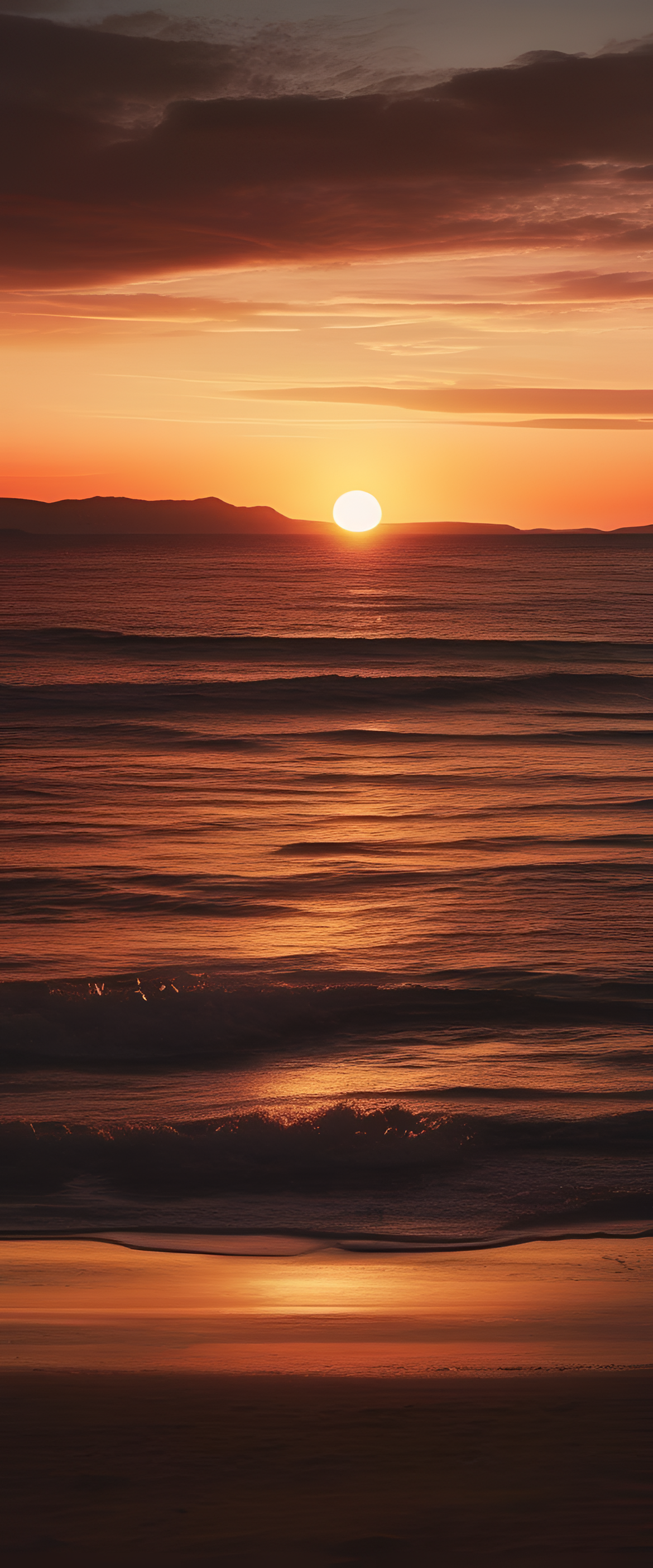 Colorful sky over calm water with sun setting behind mountains.